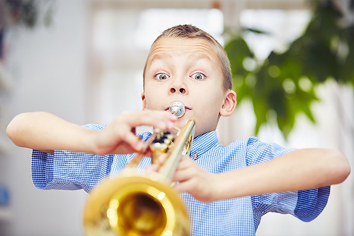 Ett barn tar i ordentligt när han spelar trumpet