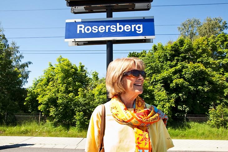 En kvinna som står och väntar på tåget vid Rosersbergs station.