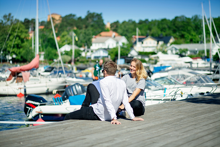 Två personer sitter på bryggan vid Sigtuna gästhamn