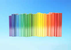 Regnbågsfärgad rad med böcker mot blå bakgrund